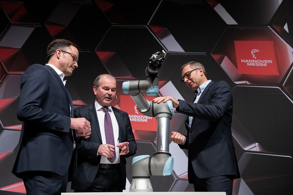 Dr. Jürgen Köckler, Per Thöresson und Jürgen von Hollen mit einem UR-Roboter während der Pressekonferenz