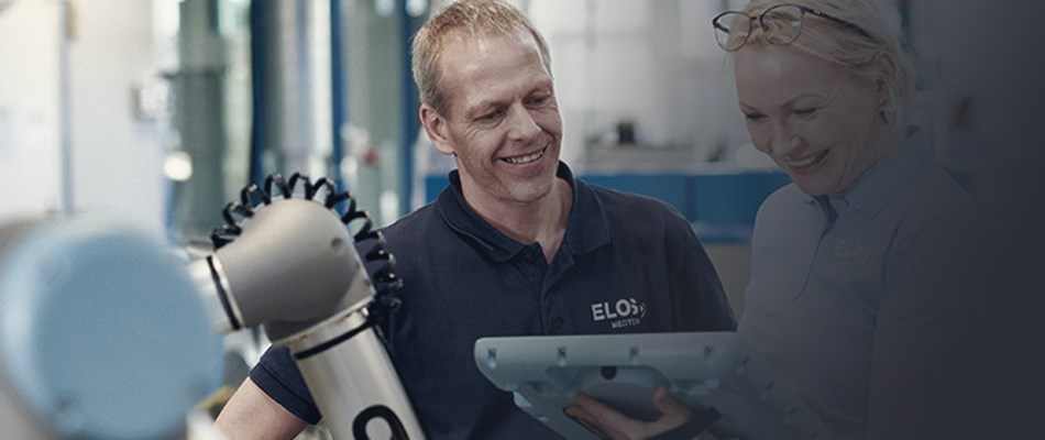 Man and woman programming collaborative robots