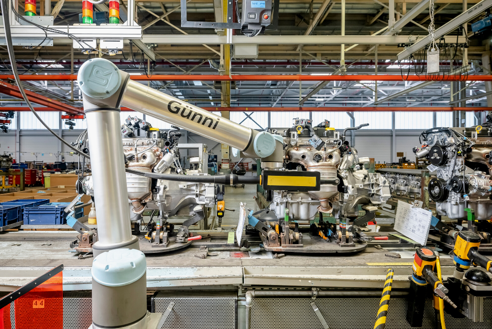 Ein kollaborierender Roboterarm UR10 montiert ein Werkstück an einem Autogetriebe.