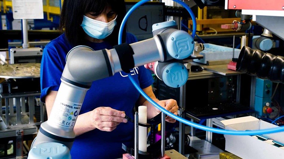 Eine Mitarbeiterin bestückt einen kollaborierendern Roboter (sog. Cobot) mit einer Sonnenbrille. Dieser führt die Anwendung zur Lasermarkierung im Anschluss völlig autonom durch.