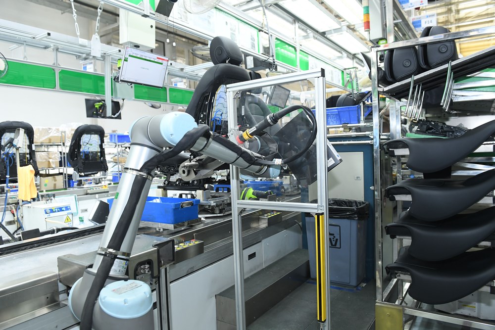 Ein kollaborierender Roboterarm von Universal Robots prüft die Qualität und schraubt Autositze.