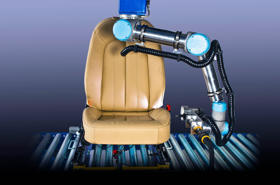 Ein Roboterarm hängt kopfüber und prüft ausgestattet mit einer Kamera einen Autositz der Firma Lear.