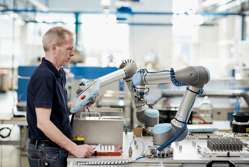 Ein Mitarbeiter bedient einen Cobot von Universal Robots