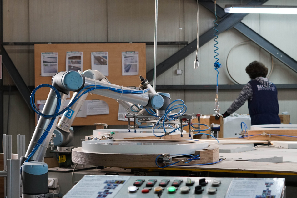 Zwei Cobots von Universal Robots arbeiten in unmittelbarer Nähe eines Menschen. 