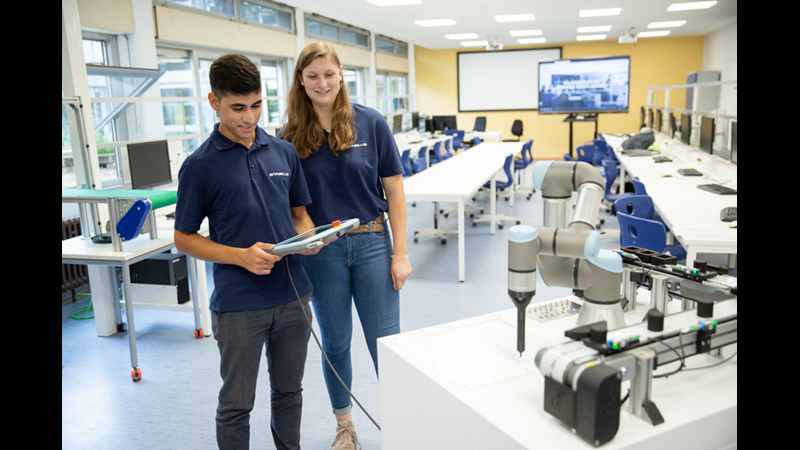 foto de estudiantes operando un cobot