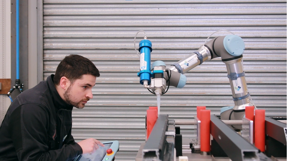 moniteur travaillant avec un robot industriel