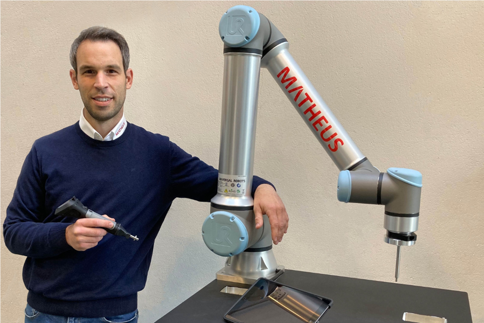 Hier sieht man Geschäftsführer Matthias Weinandy neben einem Cobot von Universal Robots.