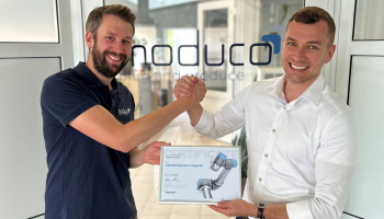 Hier sieht man einen Mitarbeiter aus Universal Roboter mit einem Mitarbeiter aus moduco GmbH mit dem Certified System Integrators (CSI)  in der Hand.