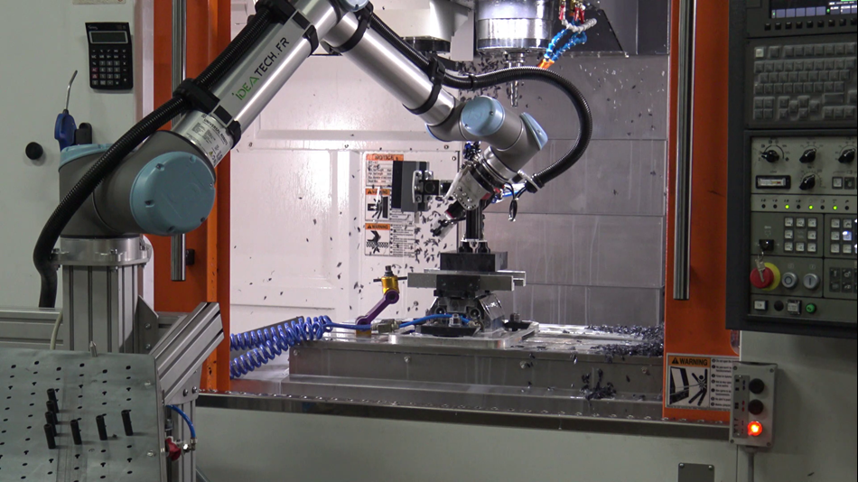 Le cobot équipé d’une ventouse à vide approvisionne automatiquement la machine