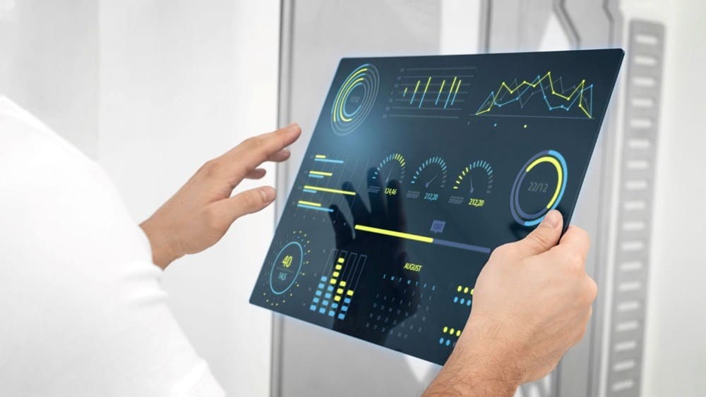 Pessoa interagindo com uma tela exibindo gráficos e indicadores, representando o monitoramento do OTIF (On Time In Full) na indústria.